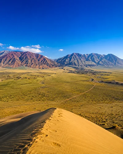 Panoramic view of the Big and Small Kalkan mountains near the Singing Dune